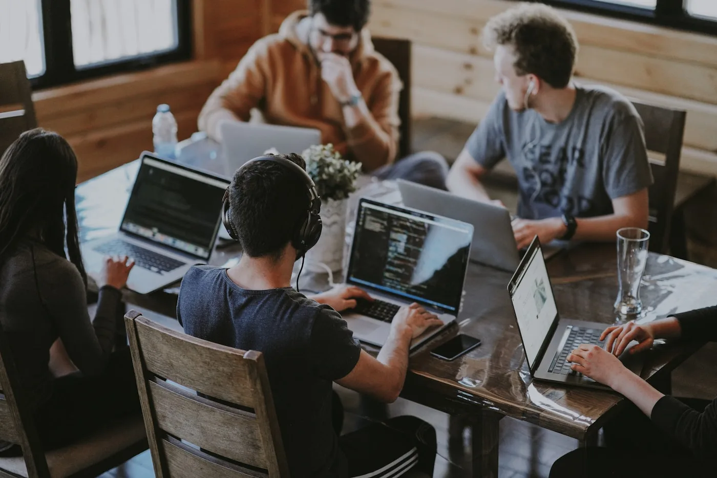 Small team at laptops — internal how-to questions answered on Slack and email from your playbooks